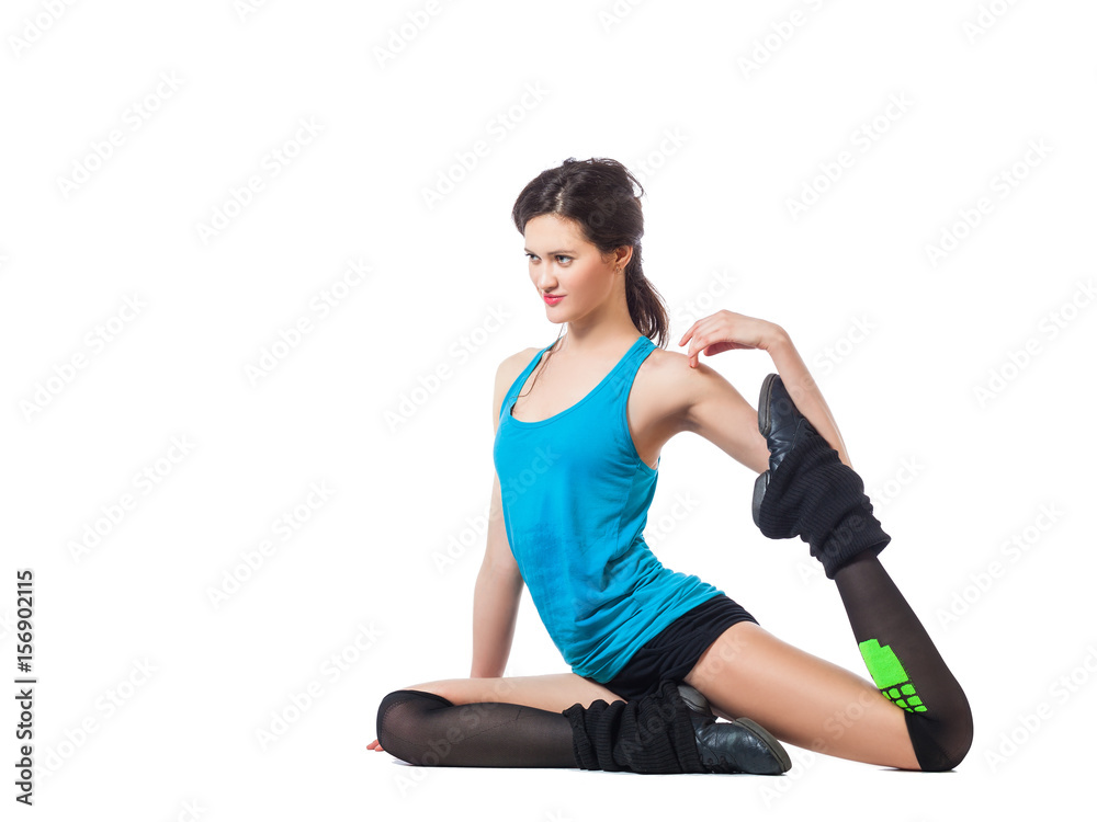 Sporty woman in short shorts and blue top makes stretching on isolated background