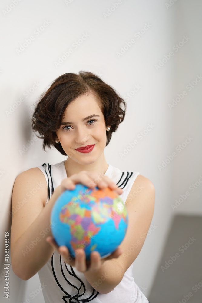 selbstbewusste junge frau hält einen globus in den händen selbstbewusste junge frau hält einen globus in den händen
