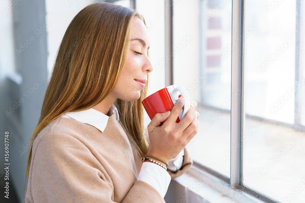 selbstbewusste junge frau genießt eine tasse tee selbstbewusste junge frau genießt eine tasse tee