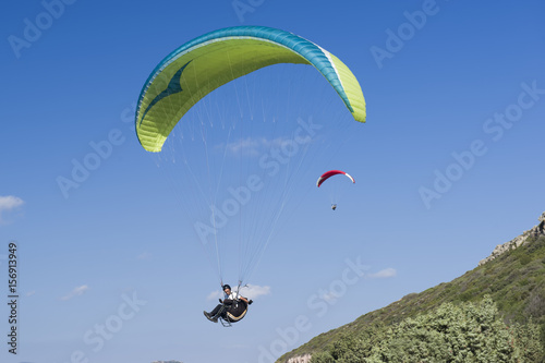 Paragliding in blue cloudy sky