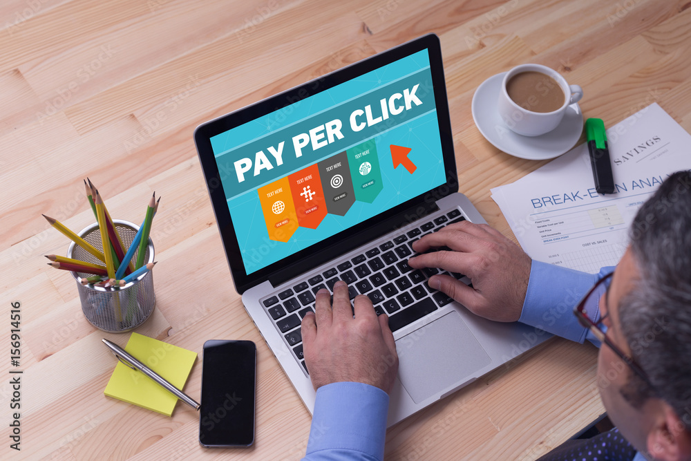 Man working on laptop with PAY PER CLICK on a screen Man working on laptop with PAY PER CLICK on a screen