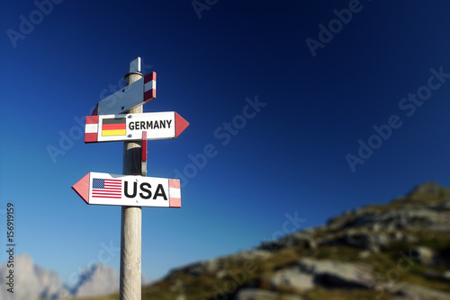 USA and German flags on signpost, politics concept photo