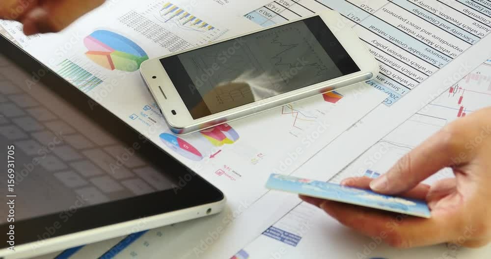 4k Businesspeople input credit card number on smartPhone,finance pie charts & smartPhone on the table. 4k Businesspeople input credit card number on smartPhone,finance pie charts & smartPhone on the table.
