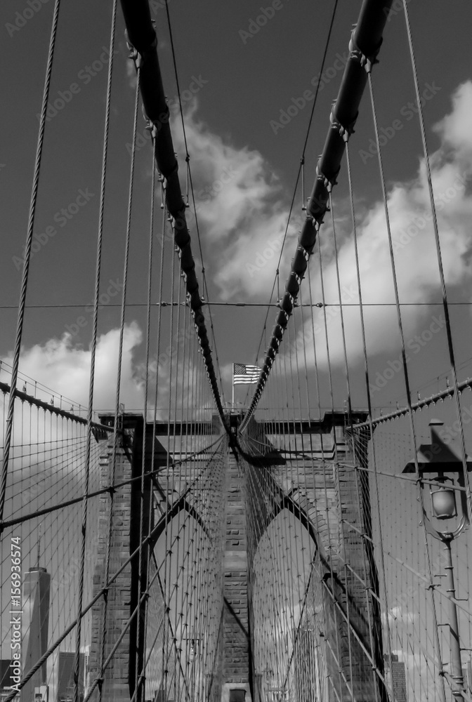Fototapeta premium Brooklyn Bridge with American flag in black and white