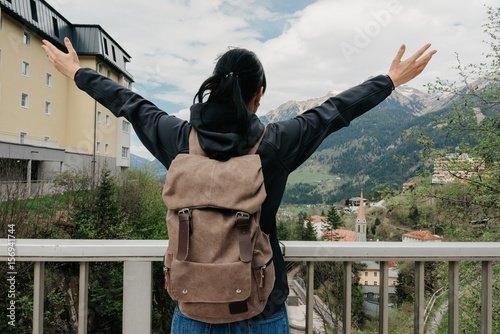 Austria. Bad Gastein. A traveler with a backpack is standing on a bridge overlooking the Alpine mountains
