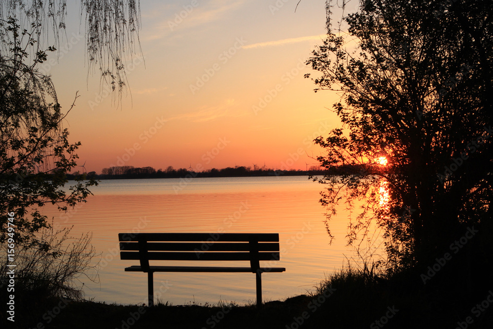 Sunset with bench in early spring Lake Erie