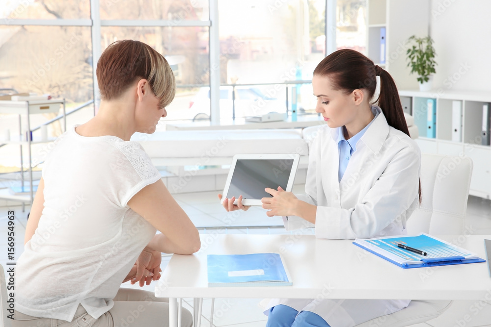 Orthopedist examining middle-aged woman in clinic Orthopedist examining middle-aged woman in clinic