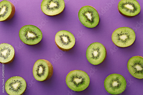 Kiwi slices pattern on a purple background. Repetition concept. Top view. Flat lay