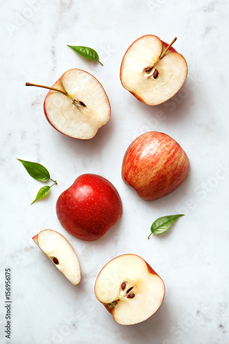 Apples flat lay on a marble background. Group of sliced and whole apple fruits viewed from above. Top view