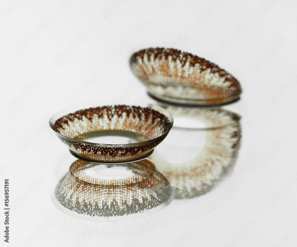 Brown contact lenses on light background with reflection Brown contact lenses on light background with reflection