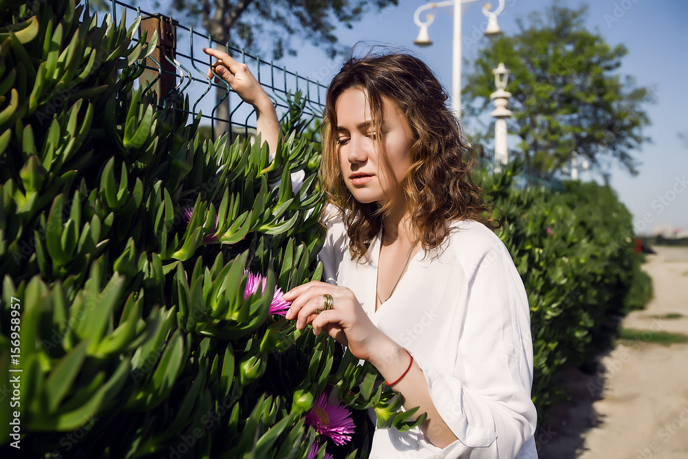 Beautiful Girl in a park, woman with curly hair.Summer sunny lifestyle fashion portrait of young stylish hipster woman,wearing cute trendy outfit,enjoy her weekends,girl at sea,white shirt,skin care Beautiful Girl in a park, woman with curly hair.Summer sunny lifestyle fashion portrait of young stylish hipster woman,wearing cute trendy outfit,enjoy her weekends,girl at sea,white shirt,skin care