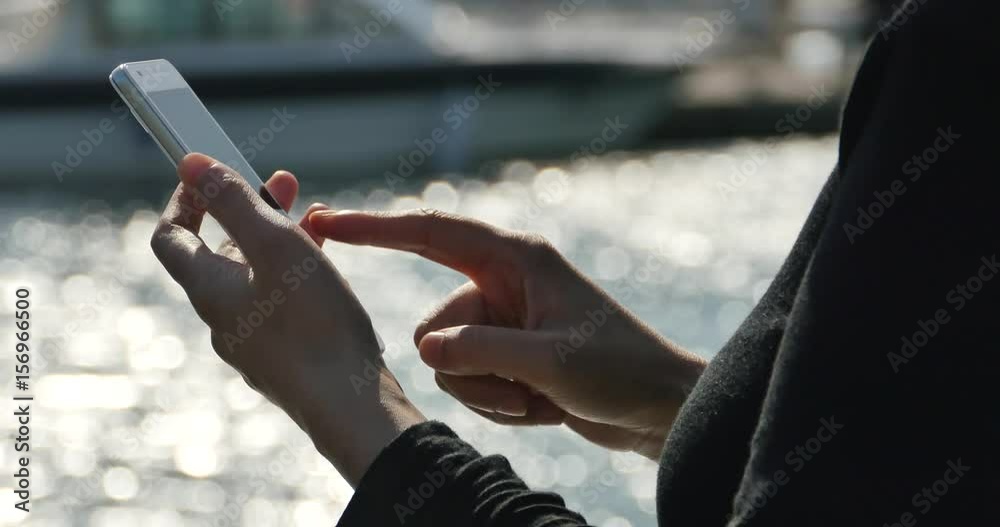 4k A girl using a smartphone at seaside,yacht & sailing in the harbour,Sparkling water surface. 4k A girl using a smartphone at seaside,yacht & sailing in the harbour,Sparkling water surface.