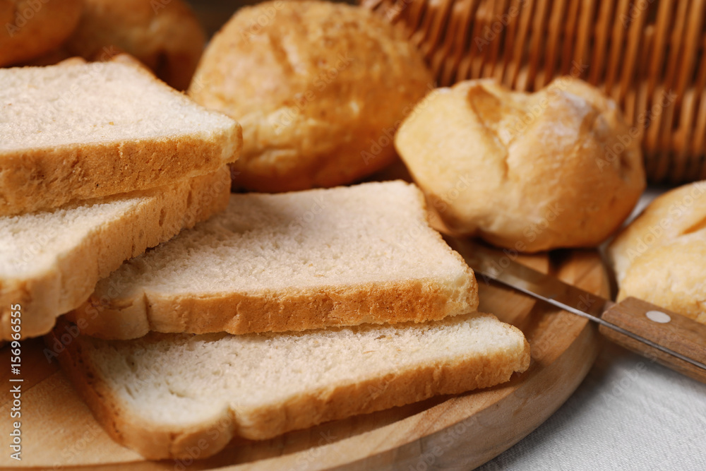 Delicious sliced bread on wooden cutting board