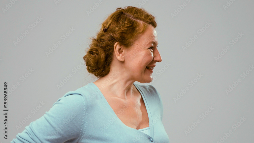 Actress in studio side view. Close up portrait of midaged red-haired woman in side view on white. Actress in blue jumper shows different emotions. Red-haired curly actress shows different emotions. Actress in studio side view. Close up portrait of midaged red-haired woman in side view on white. Actress in blue jumper shows different emotions. Red-haired curly actress shows different emotions.