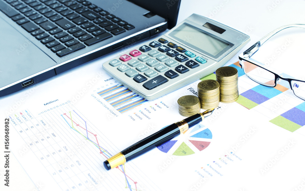 Financial concept with coins stack and calculator and fountain pen and eyeglasses and labtop on document chart data backgrounds Financial concept with coins stack and calculator and fountain pen and eyeglasses and labtop on document chart data backgrounds
