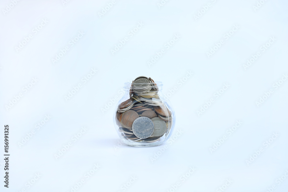International coins in a glass jar on white background. International coins in a glass jar on white background.