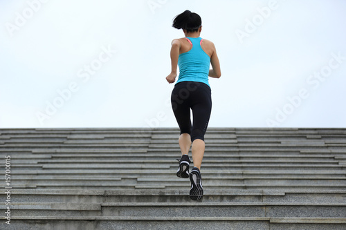 Sporty female running up on stone stairs . © lzf