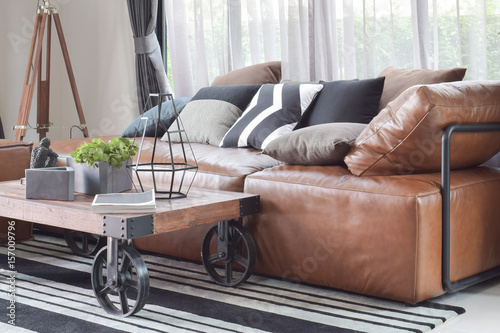 Wood center table with wheel and light brown leather sofa in industrial style decoration