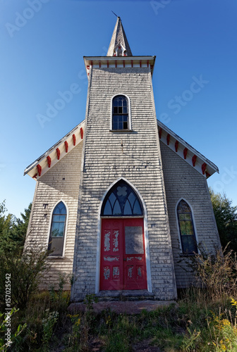 Creepy abandoned church in overgrown field on Prince Edward Island, Canada. Vertical.