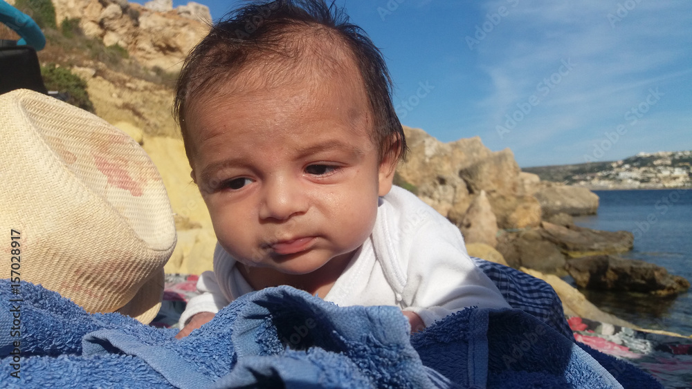 baby boy laying down on rocky beach baby boy laying down on rocky beach