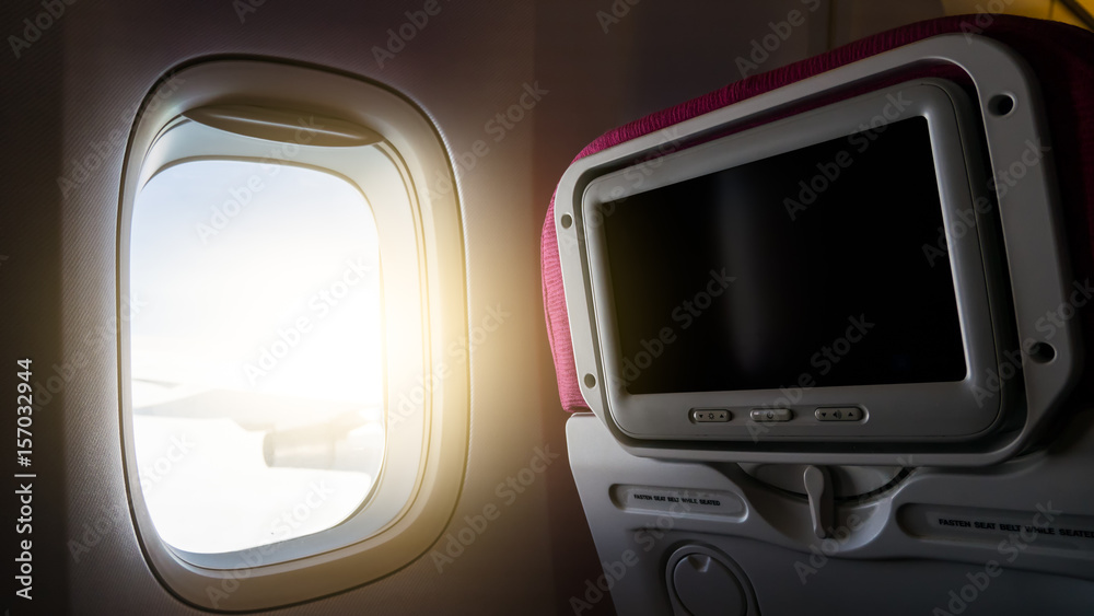 Window with sunlight and Private monitor on airplane seat to entertainment service for passenger in travel concept.. Window with sunlight and Private monitor on airplane seat to entertainment service for passenger in travel concept..