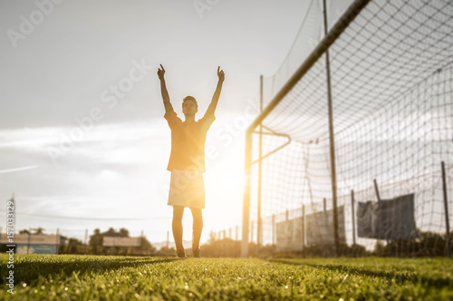 Successful soccer player laughed up his arms to the sky photo