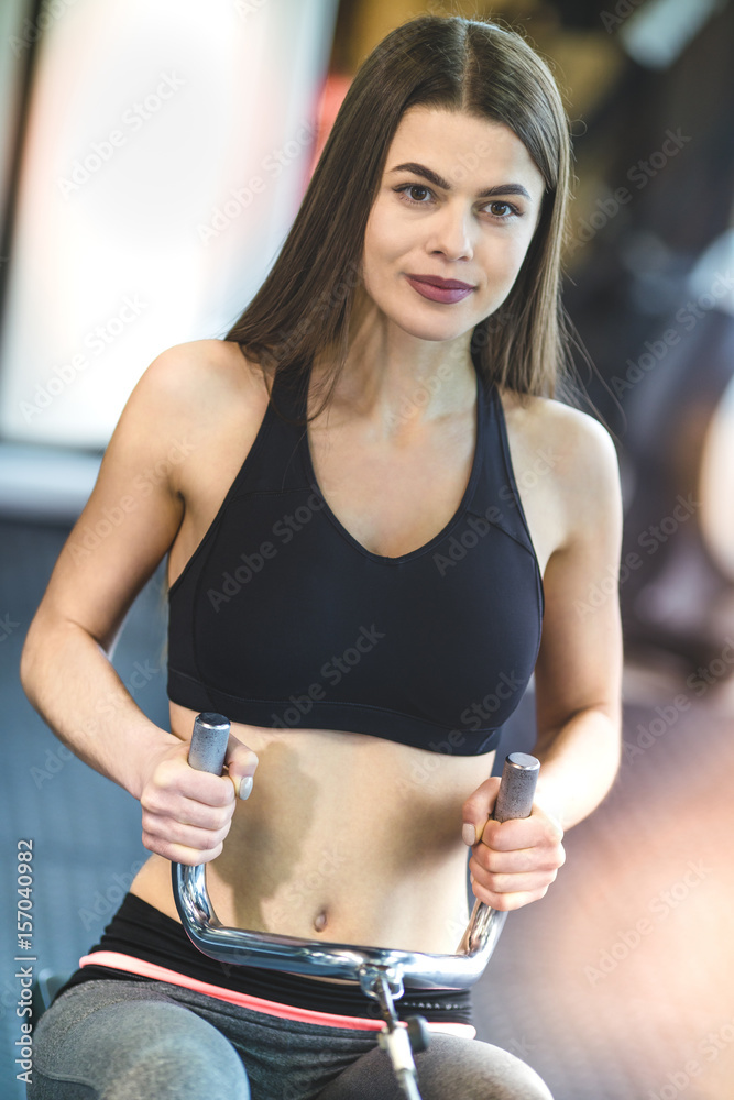 The athletic woman doing exercise on the training apparatus The athletic woman doing exercise on the training apparatus