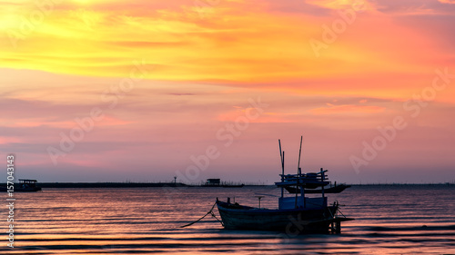 small fishing boat at beach with sunset