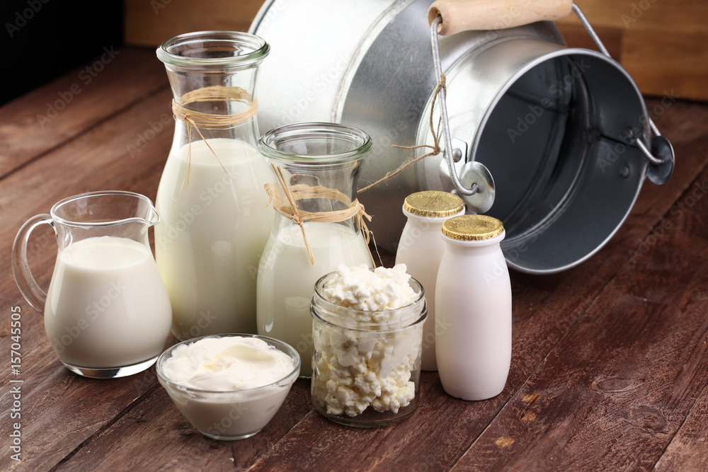 milk products - tasty healthy dairy products on a table on: sour cream in a white bowl, cottage cheese bowl, cream in a a bank and milk jar, glass bottle and in a glass milk products - tasty healthy dairy products on a table on: sour cream in a white bowl, cottage cheese bowl, cream in a a bank and milk jar, glass bottle and in a glass