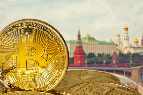 Photo Golden Bitcoins (new virtual money). Coins in the background of Moscow. Conceptual photo.  photo