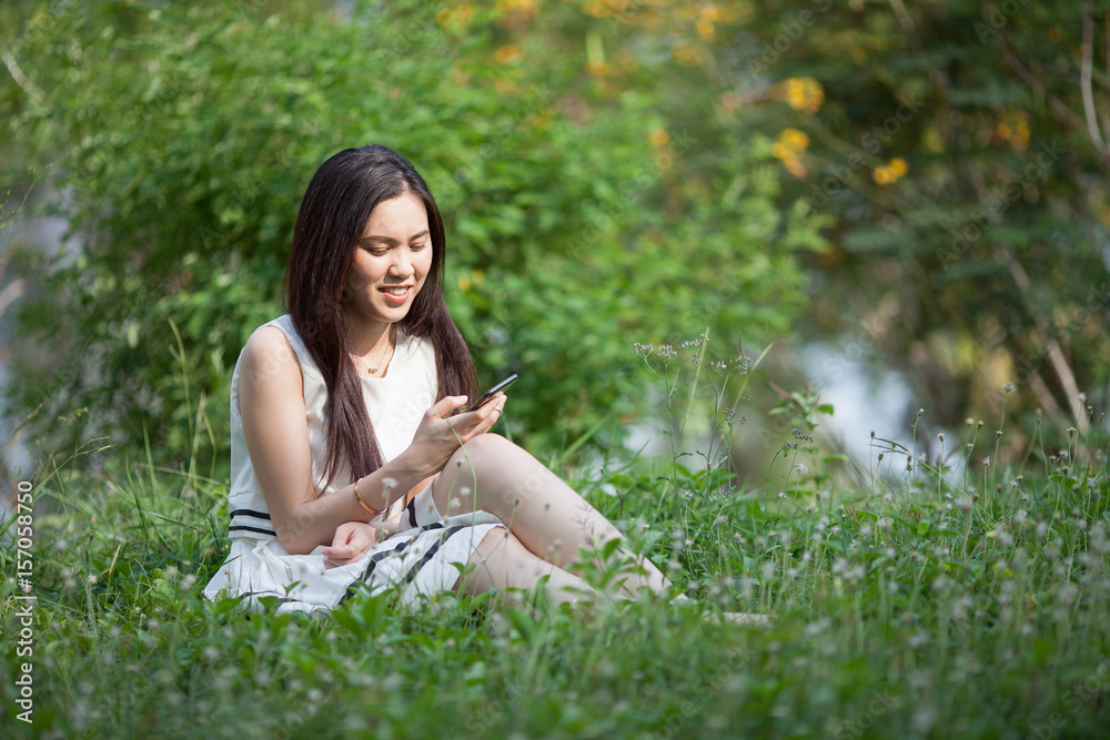 Thai pretty woman using mobile at the park Thai pretty woman using mobile at the park