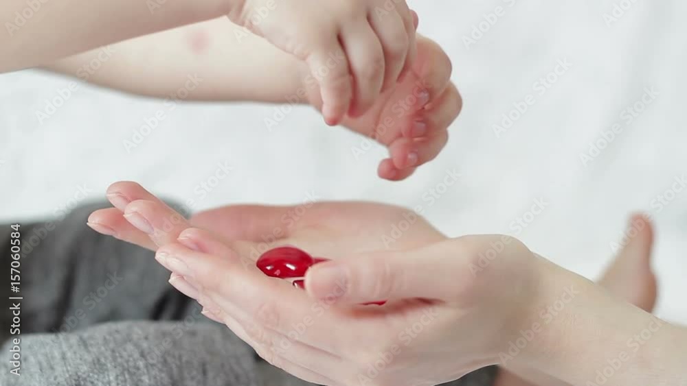 A child from hands to mother hands pours out red hearts. A child from hands to mother hands pours out red hearts.