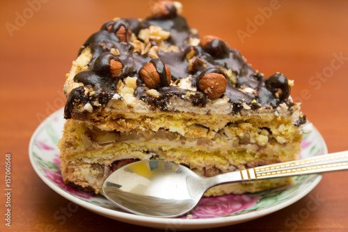Piece of cake with hazelnuts and chocolate in a saucer