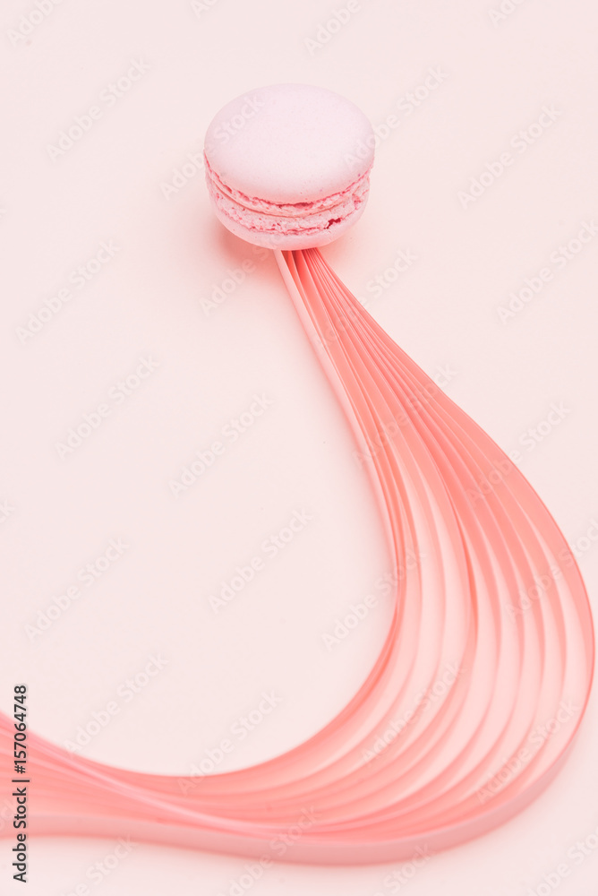 Pink Macaron and paper strips on a light background Pink Macaron and paper strips on a light background