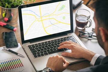 Man at work with a laptop - map on the computer screen