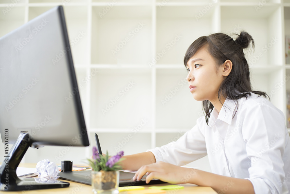 Graphic designer using graphics tablet and computer in the office Graphic designer using graphics tablet and computer in the office