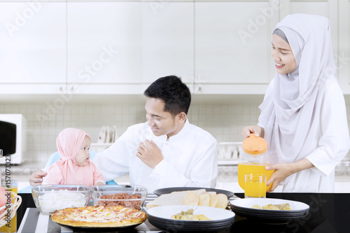 Smiling family eating together in kitchen