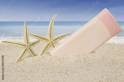 Suncream and starfishes on beach