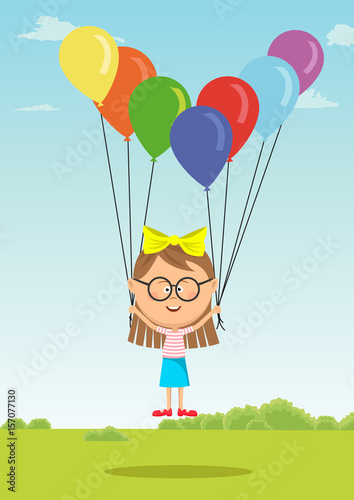 Little girl with glasses flying with multicolored balloons on meadow