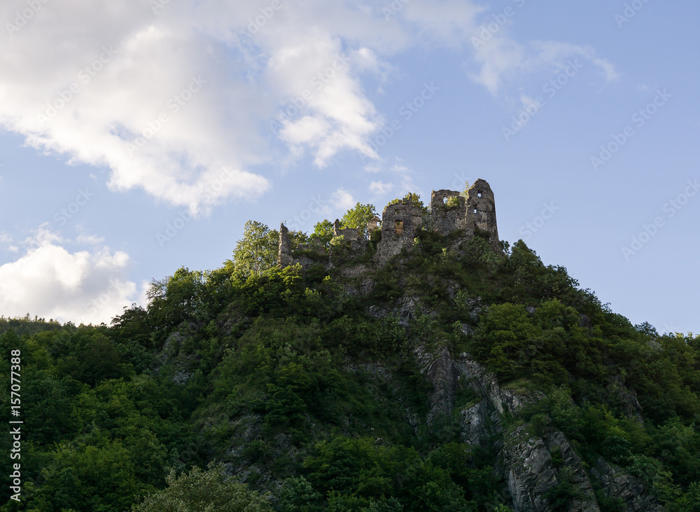 Castle on the rock in green woods during summer. Slovakia
