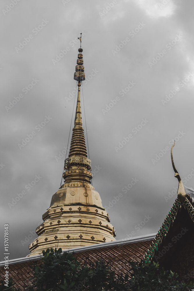 Fototapeta premium Golden temple in Thailand with dark clouds