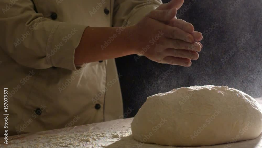 Young chef clapping his hands filled with flour