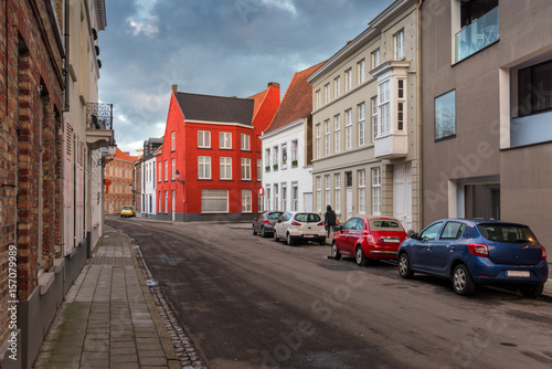 Empty Street In Old Town Bruges (Belgium),With Red Brick Buildings At Cloudy Day.Off-Season Realistic View With Medieval Color Traditional Houses And Several Cars.Street In Historic Centre Of Bruges © Vlad Sokolovsky