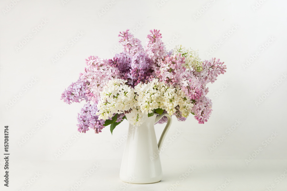 Lilac bouquet in a vase on white background