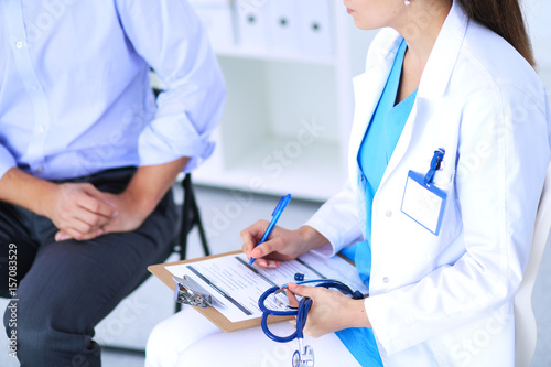 Doctor woman sitting with male patient at the desk