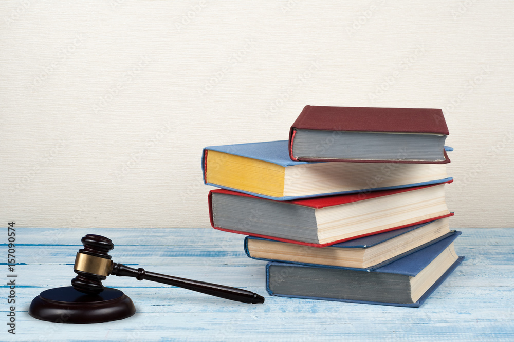 Law concept open book with wooden judges gavel on table in a courtroom or law enforcement office, beige background. Copy space for text. Law concept open book with wooden judges gavel on table in a courtroom or law enforcement office, beige background. Copy space for text.