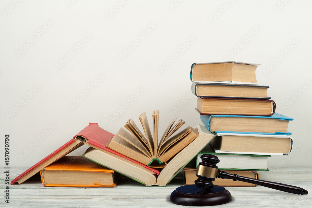 Law concept open book with wooden judges gavel on table in a courtroom or law enforcement office, white background. Copy space for text. Law concept open book with wooden judges gavel on table in a courtroom or law enforcement office, white background. Copy space for text.