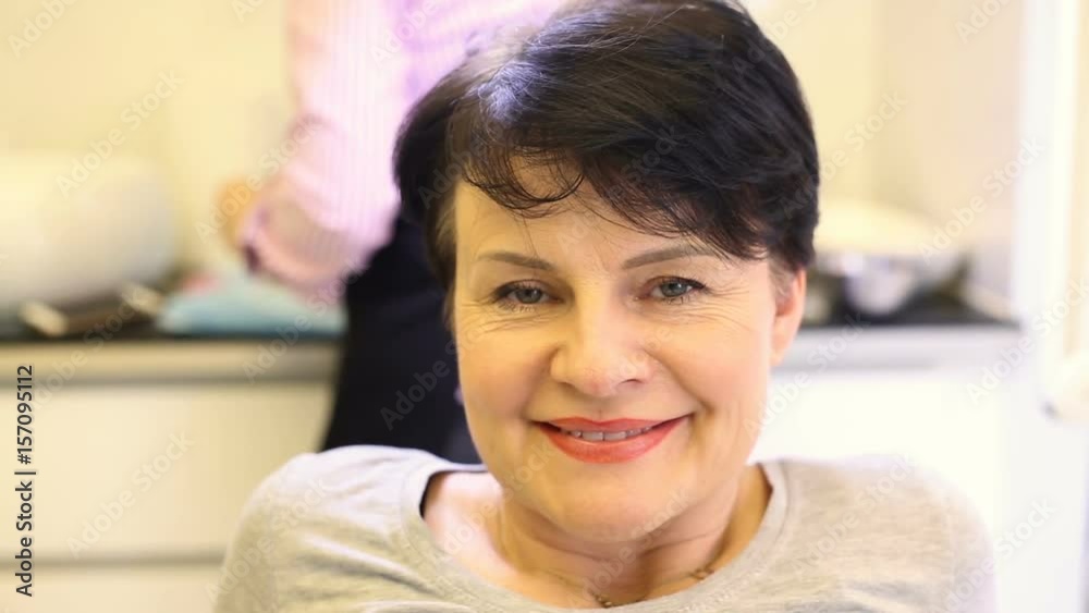 Beautiful lady sitting in the beauty salon and smiling to the camera Beautiful lady sitting in the beauty salon and smiling to the camera