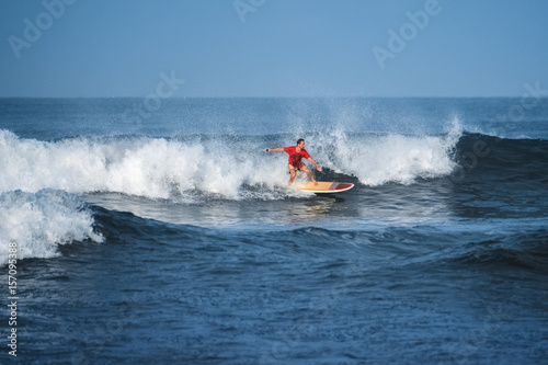 Amateur surfer rides the wave in the ocean