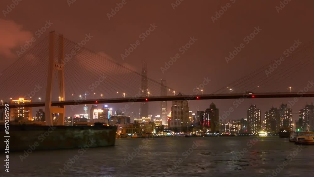 Timelapse,busy shipping on huangpu river,across the sea bridge at night in shanghai,nanpu bridge,Brightly lit urban building background. Timelapse,busy shipping on huangpu river,across the sea bridge at night in shanghai,nanpu bridge,Brightly lit urban building background.